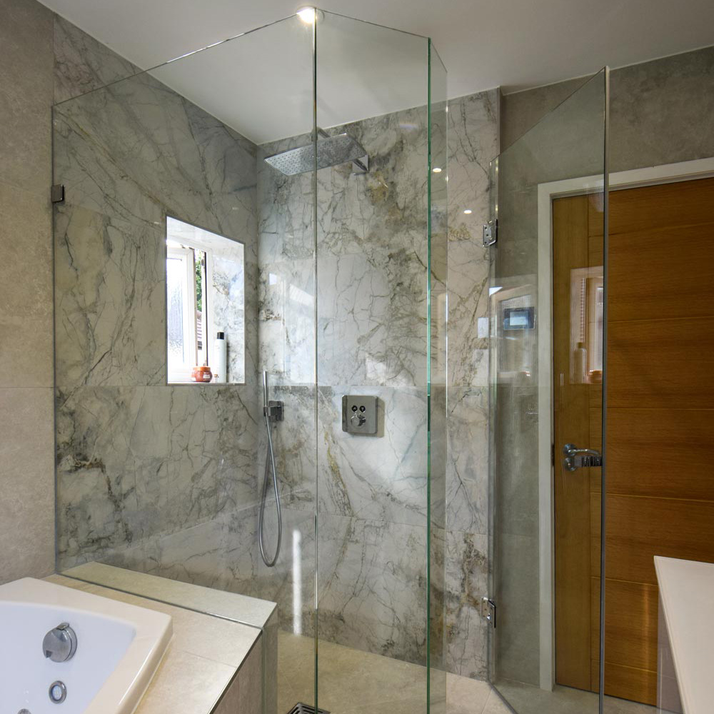 frameless shower enclosure next to a bath